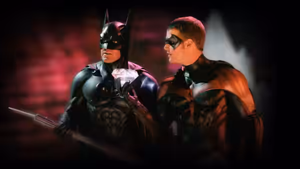 Batman (George Clooney) and Robin (Chris O'Donnell) standing close with weapons