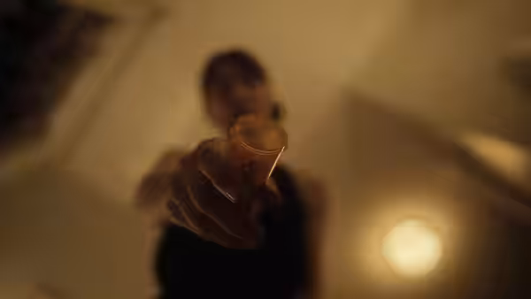 A woman holding out a prescription pill bottle toward the camera