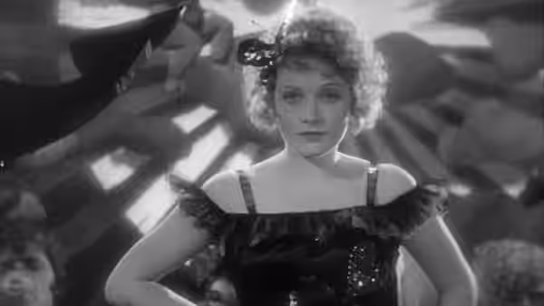 Lola Lola (Marlene Dietrich) stands center stage in a feather-trimmed costume