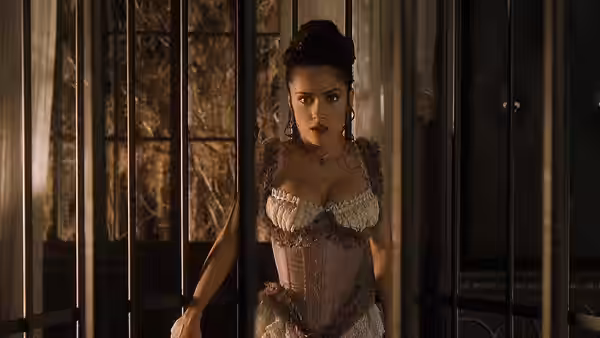 Rita Escobar (Salma Hayek) standing behind prison bars in a corset dress