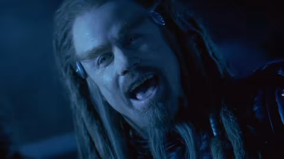 Terl (John Travolta) with dreadlocks shouting mouth open wearing ear devices