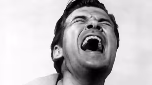 A man throws his head back and screams