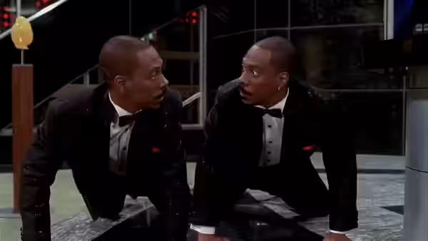 Eddie Murphy and another man in tuxedos look surprised