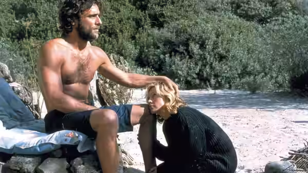 Guido (Adriano Giannini) sits as Amber Leighton (Madonna) kneels on the shore