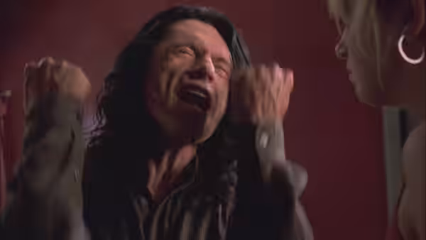 Johnny (Tommy Wiseau) crying with raised fists beside Lisa (Juliette Danielle)