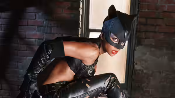 Catwoman (Halle Berry) crouching in a ready stance by a brick wall