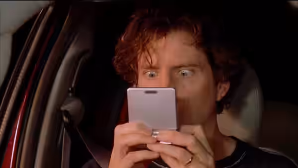Tim Avery (Jamie Kennedy) stares at his phone inside a car