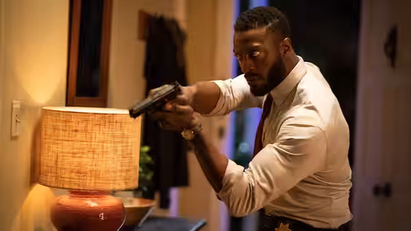 James Lanier (Aldis Hodge) aims a handgun inside a house