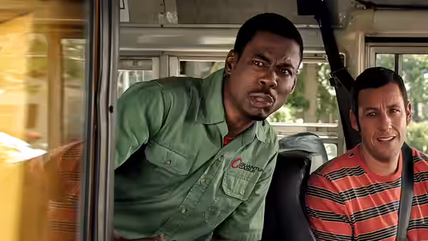 Kurt McKenzie (Chris Rock) leans forward inside a vehicle beside Lenny Feder