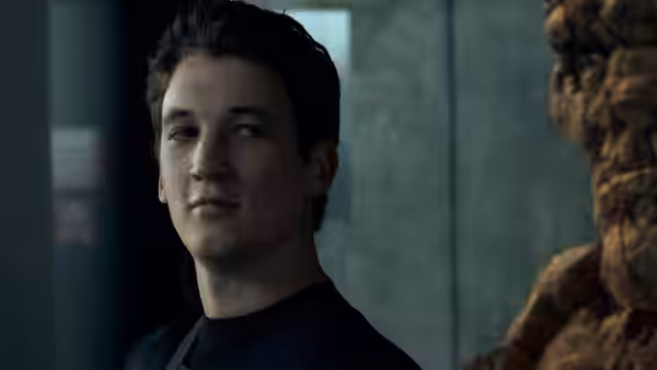 Reed Richards (Miles Teller) looking aside with The Thing visible next to him