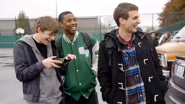 Andrew Detmer films as Steve Montgomery and Matt Garetty laugh together in a parking lot