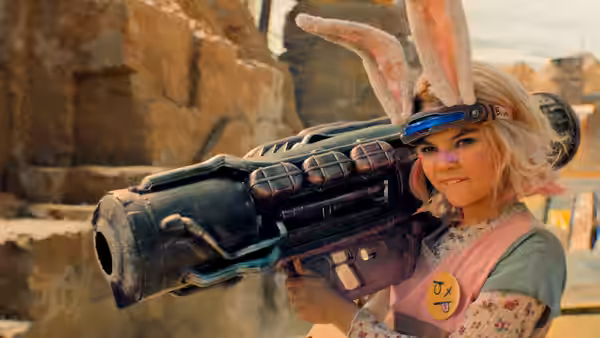 Tiny Tina (Ariana Greenblatt) holding a large weapon in desert ruins