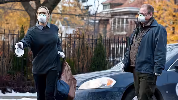 Woman and man in masks beside a car on a suburban street