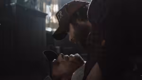 Dale (Tyler Labine) lies on the floor as Tucker (Alan Tudyk) leans over him indoors