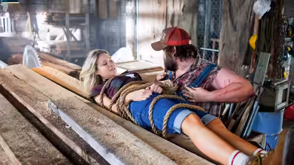 Allison (Katrina Bowden) lies bound on planks as Dale (Tyler Labine) tends to her