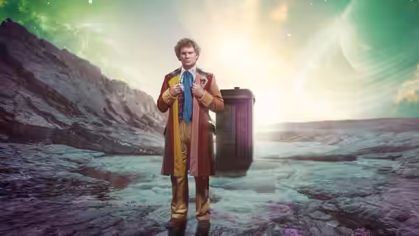 Colin Baker as the Doctor adjusting his bow tie beside the TARDIS on rocks