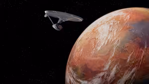 Starship Enterprise approaching a large reddish planet in space