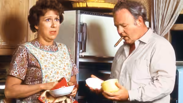Edith (Jean Stapleton) and Archie (Carroll O'Connor) holding bowls in the kitchen