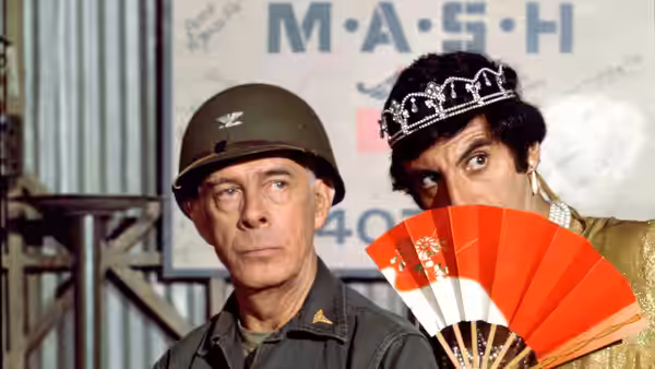 Sherman Potter (Harry Morgan) beside Maxwell Klinger (Jamie Farr) with a fan
