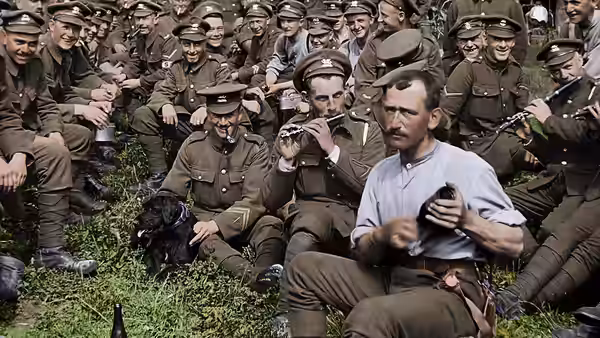 A seated soldier plays a flute as fellow soldiers gather around him outdoors