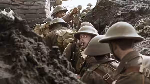 British soldiers in steel helmets move through a narrow, sandbagged trench