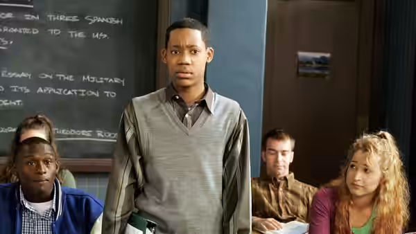Chris standing at the front of a classroom with students watching