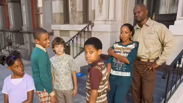 Group of children and adults posing together on building steps