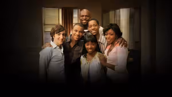 Family group hugging and posing together indoors at home