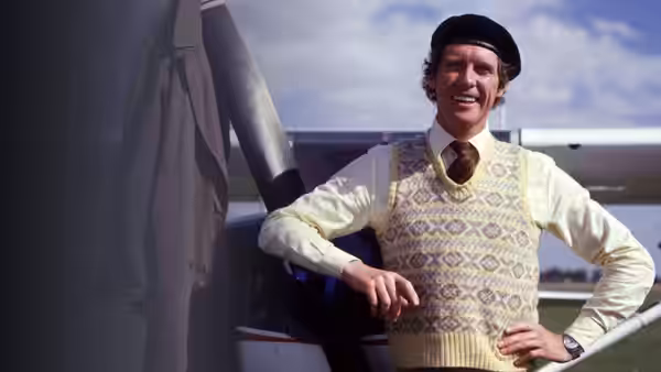 Frank Spencer (Michael Crawford) standing beside an airplane on an airfield