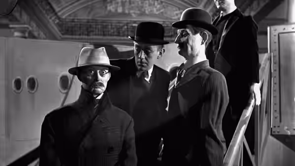 Four men in hats stand together inside a train carriage