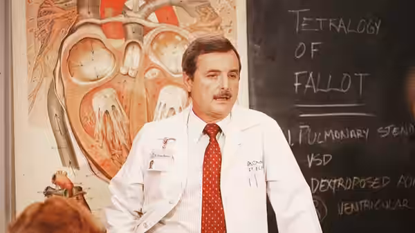 Doctor stands before a chalkboard diagram of tetralogy of fallot