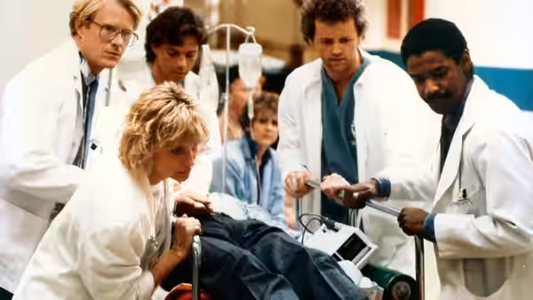 Medical team treats a patient on a gurney in a busy hospital