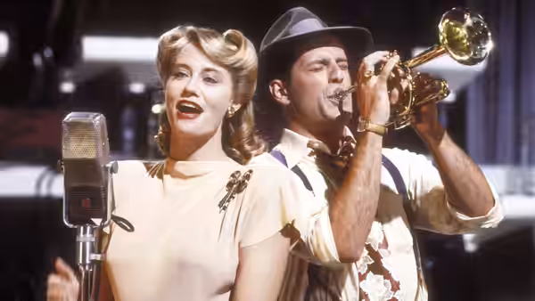 Blonde woman singing into vintage microphone as man plays trumpet