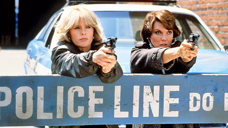 Christine Cagney (Meg Foster) and Mary Beth Lacey (Tyne Daly) aiming guns over police line
