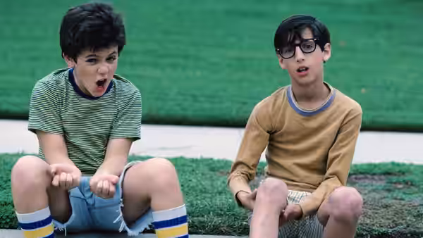 Kevin Arnold (Fred Savage) and Paul Pfeiffer (Josh Saviano) sit on the grass with mouths open