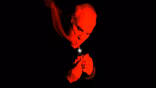 Wilson (Terence Stamp) lighting a cigarette in red light