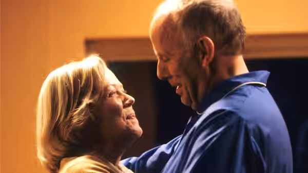 Victor Meldrew (Richard Wilson) and Margaret Meldrew (Annette Crosbie) smile while facing each other closely