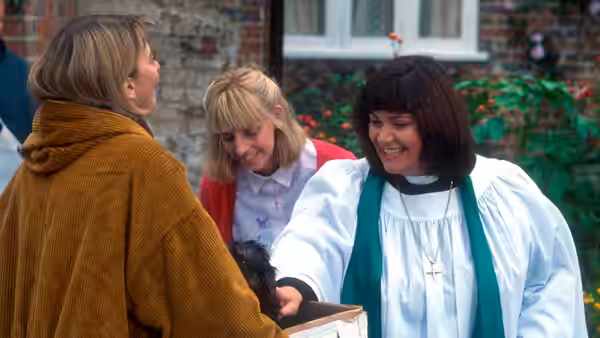 Revd Geraldine Granger (Dawn French) holding a dog while chatting with two women