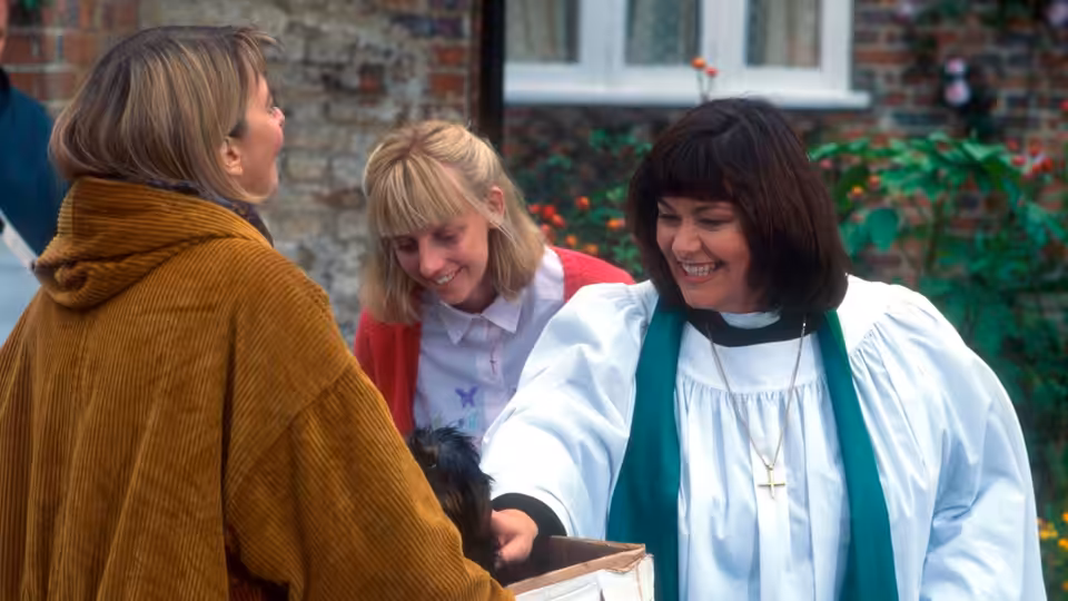 Revd Geraldine Granger (Dawn French) holding a dog while chatting with two women