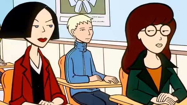 Three students seated at desks inside a classroom