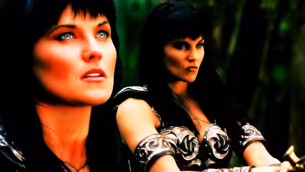 Xena (Lucy Lawless) looking upward beside another armored woman in the woods