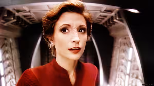 A woman with styled hair looking upward inside a corridor