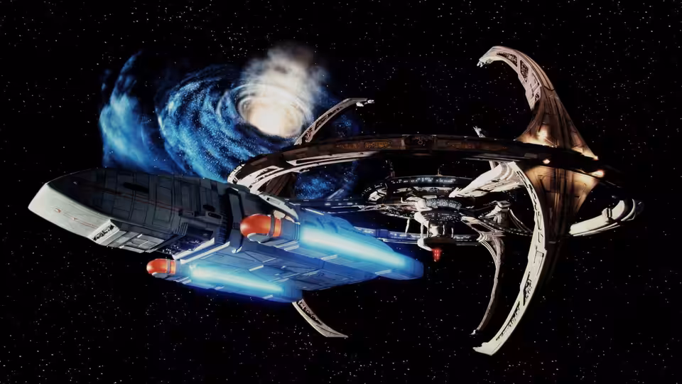Two starships flying past a glowing blue nebula in space