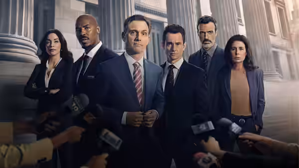 Group of suited professionals facing microphones outside a columned building
