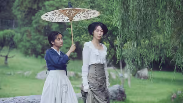 Sook-hee (Kim Tae-ri) holding a parasol beside Lady Hideko (Kim Min-hee) in a garden