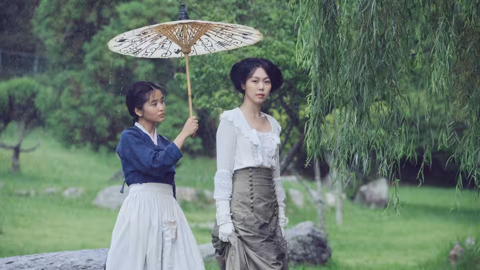 Sook-hee (Kim Tae-ri) holding a parasol beside Lady Hideko (Kim Min-hee) in a garden