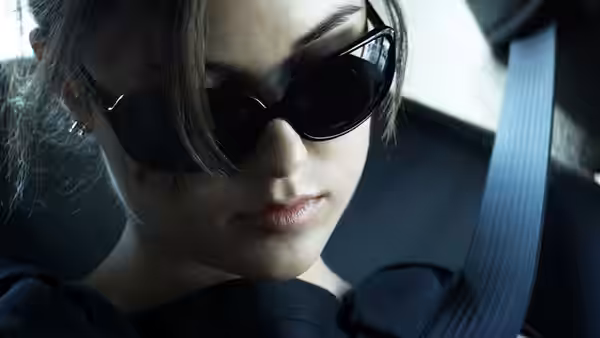 Chelsea (Sasha Grey) in the passenger seat of a car wearing sunglasses