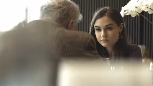 Chelsea (Sasha Grey) seated across from an older man at a restaurant table