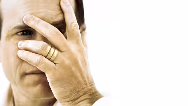 Bill Paxton holding his hand to his forehead wearing rings