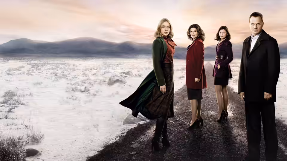 Three women and a man standing on a snowy rural road